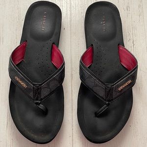 Black and grey coach flip flops.
